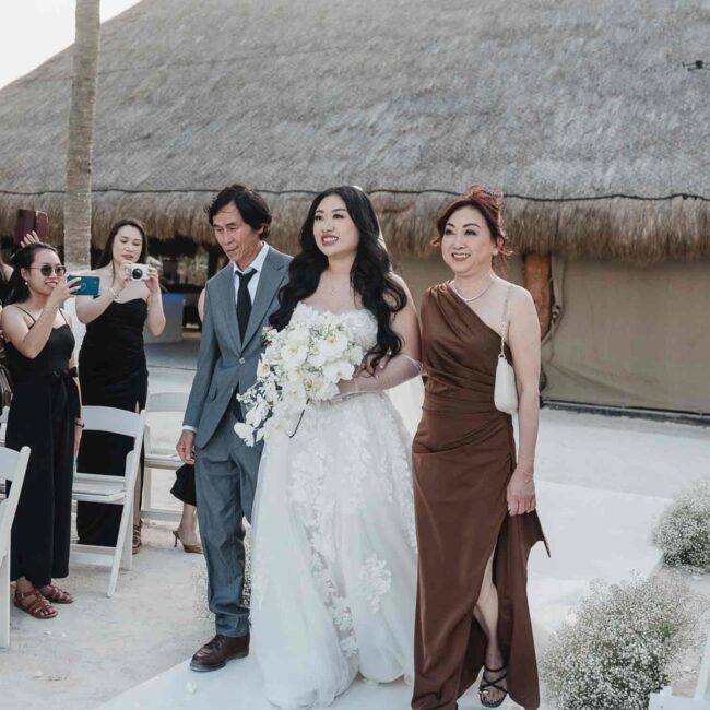 The bride walking down the aisle with her parents