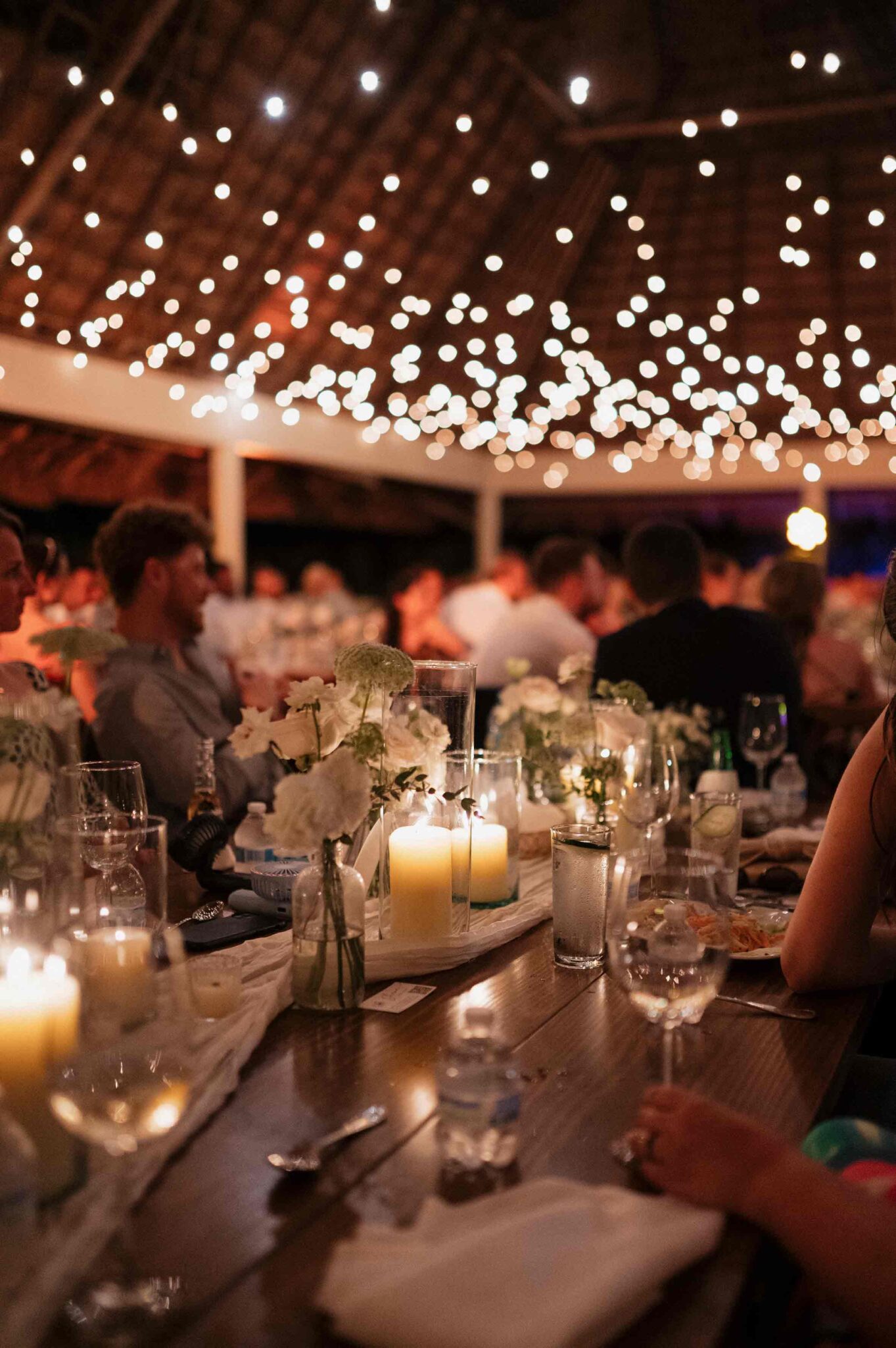 Romantic candlelight wedding dinner with floral centerpieces and warm lighting