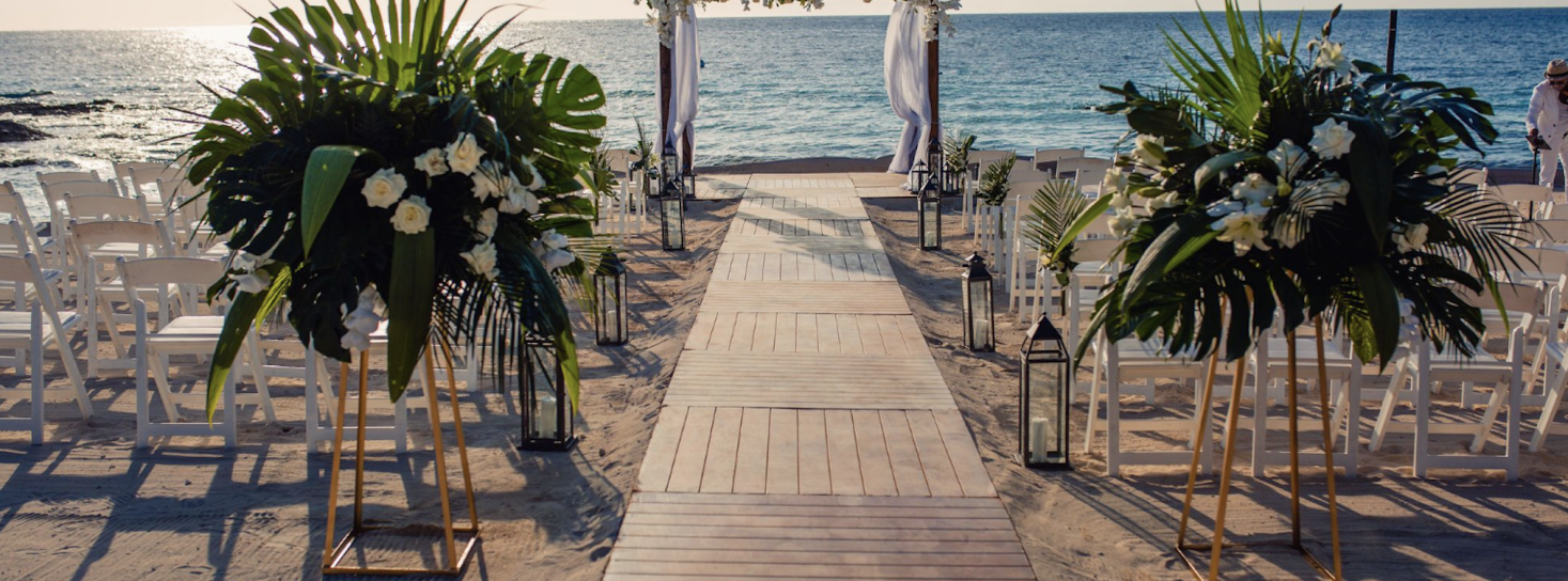 Beach wedding ceremony aisle with chairs and flowers in Riviera Maya
